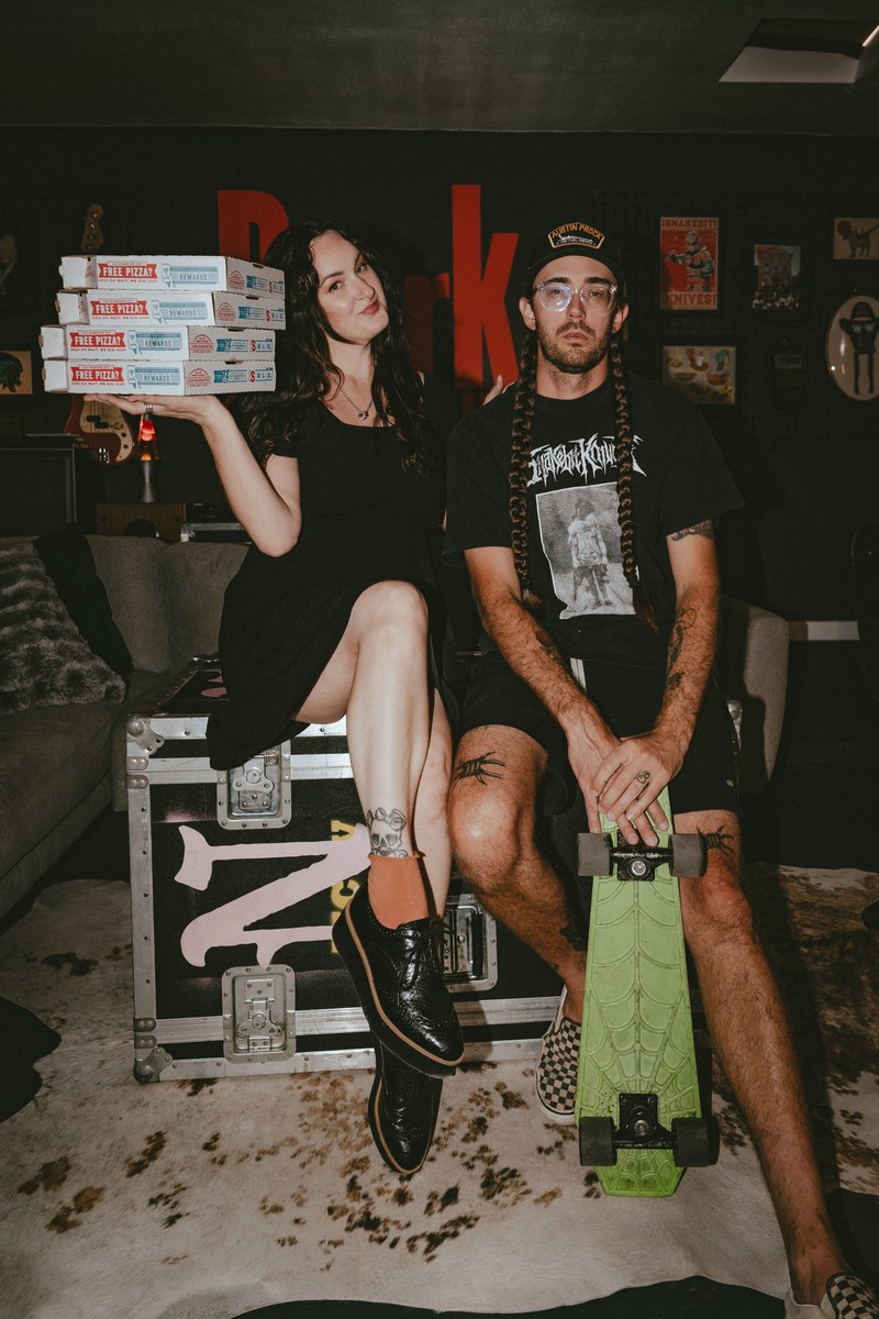 Steven and Brianna, co-founders of Dork Social Club, sitting together in their branded studio