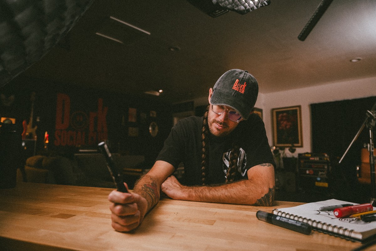 Steven at a wood desk with a notebook and pen planning before a shoot